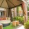 a patio with a bench and a table and chairs