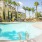 a pool with palm trees and a building in the background