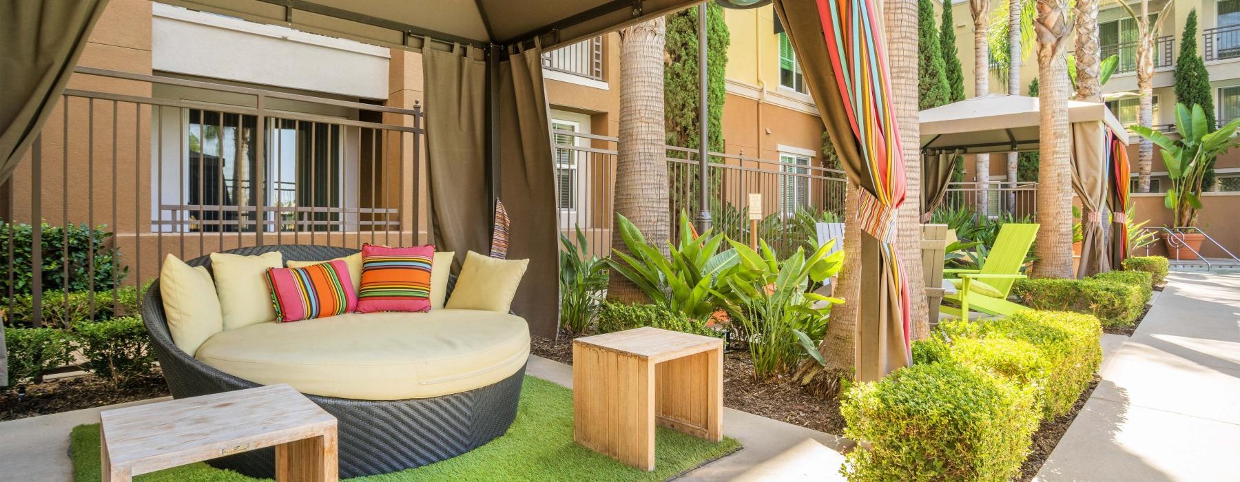 a patio with a bench and a table and chairs